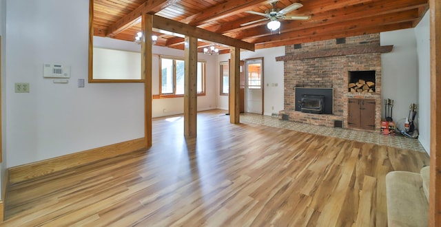 unfurnished living room featuring beam ceiling, ceiling fan with notable chandelier, wood finished floors, wooden ceiling, and baseboards