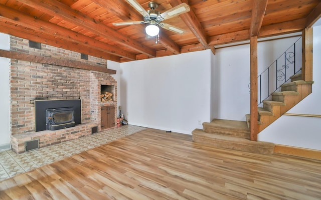 living area featuring stairs, beam ceiling, wood finished floors, and wooden ceiling