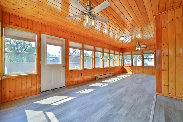 unfurnished sunroom with a healthy amount of sunlight, wooden ceiling, a baseboard heating unit, and a ceiling fan