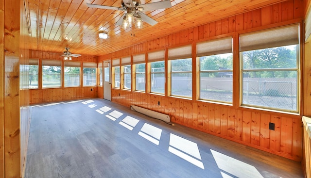 unfurnished sunroom with baseboard heating, wooden ceiling, and a ceiling fan