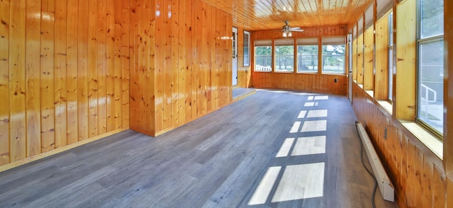 unfurnished sunroom featuring a baseboard heating unit, wooden ceiling, and a ceiling fan