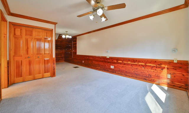 unfurnished room featuring crown molding, visible vents, wood walls, and wainscoting