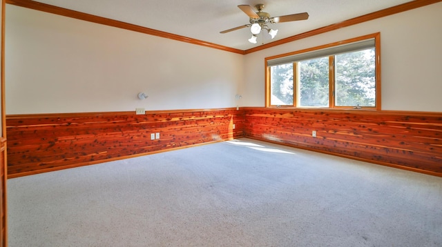 spare room with wooden walls, ornamental molding, carpet, and wainscoting