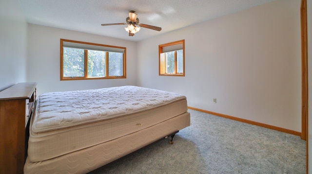 bedroom with a ceiling fan, carpet, and baseboards