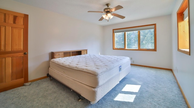 bedroom with a ceiling fan, light colored carpet, and baseboards