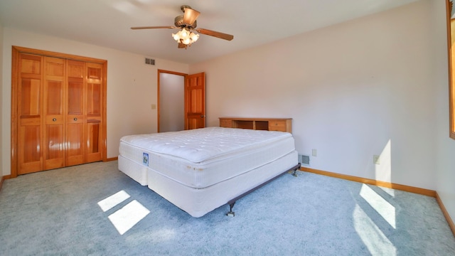 bedroom with a closet, visible vents, carpet flooring, and baseboards