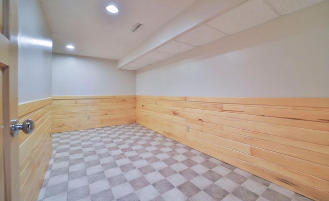 interior space with tile patterned floors, visible vents, recessed lighting, wood walls, and wainscoting