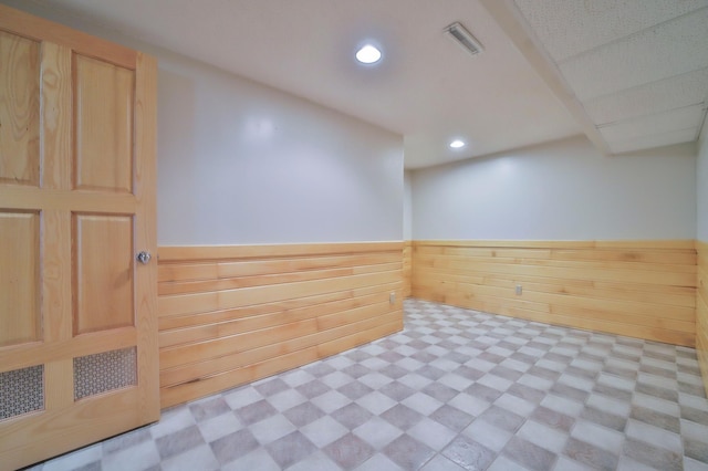 interior space with visible vents, a wainscoted wall, light floors, wood walls, and recessed lighting