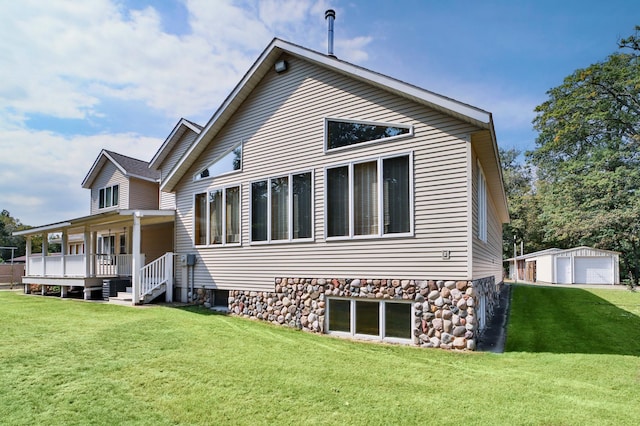 back of property featuring an outbuilding and a lawn