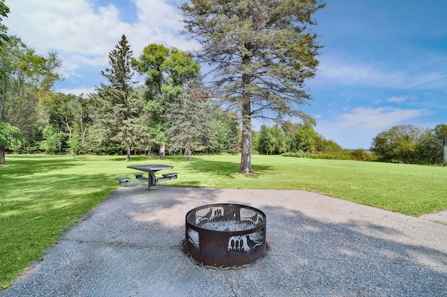 view of home's community with a fire pit and a lawn