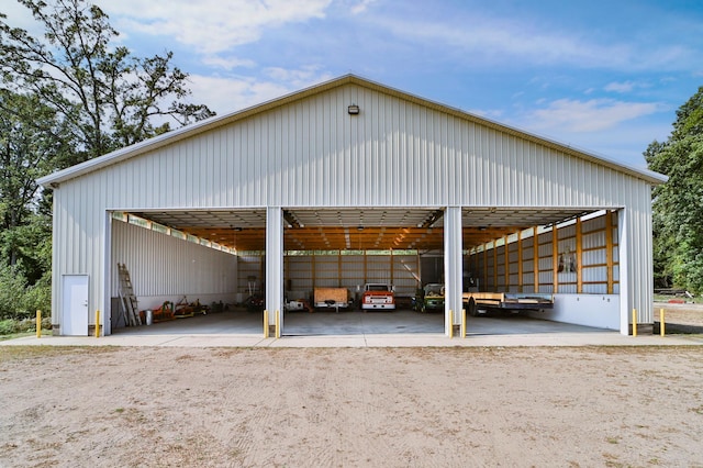 view of parking / parking lot with a carport and a pole building