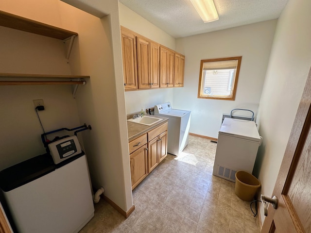 clothes washing area featuring cabinets, a textured ceiling, sink, and washer / clothes dryer