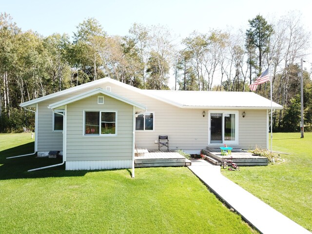 rear view of property with a deck and a lawn