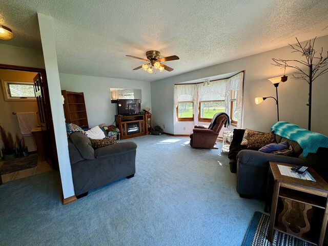 living room featuring carpet flooring, ceiling fan, and a textured ceiling