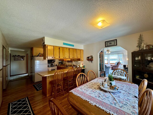 dining space featuring a textured ceiling and dark hardwood / wood-style floors