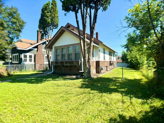 rear view of property featuring a yard