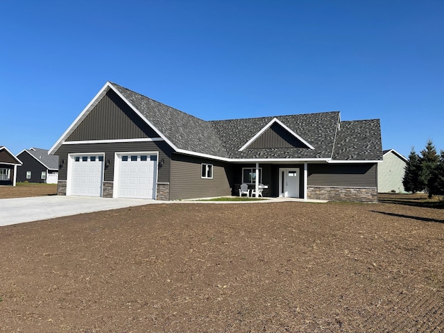 view of front facade with concrete driveway, stone siding, a garage, and board and batten siding