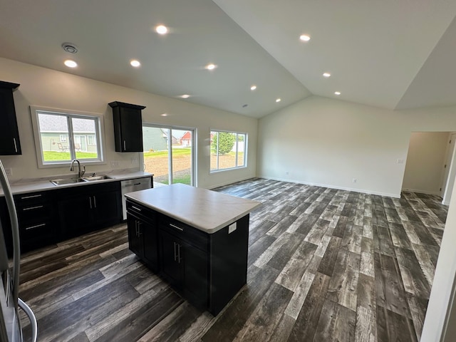 kitchen with vaulted ceiling, dark hardwood / wood-style floors, sink, and a center island