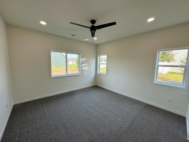 spare room with dark carpet, ceiling fan, recessed lighting, and baseboards
