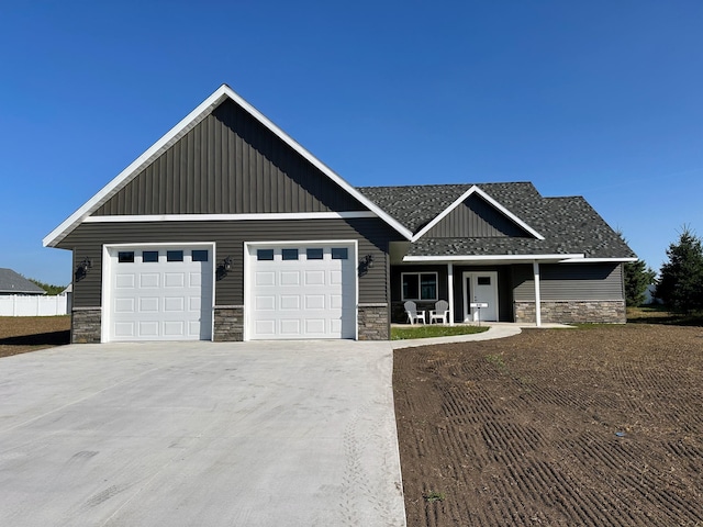 craftsman-style home featuring board and batten siding, concrete driveway, and stone siding