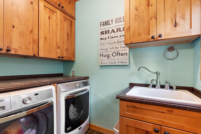 clothes washing area featuring sink, washer and dryer, and cabinets