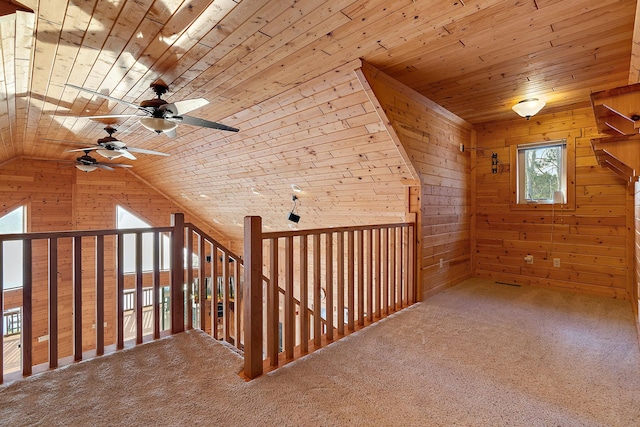 additional living space with ceiling fan, wooden ceiling, carpet floors, and wooden walls