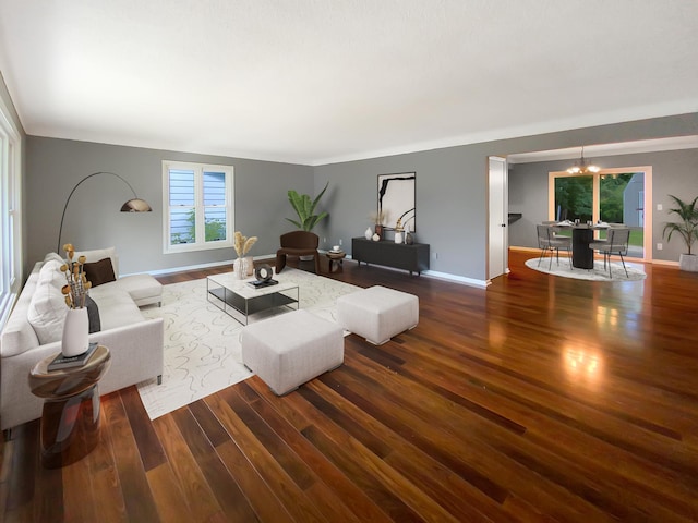 living room featuring an inviting chandelier and dark wood-type flooring