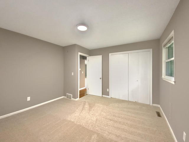 unfurnished bedroom featuring carpet flooring and a closet