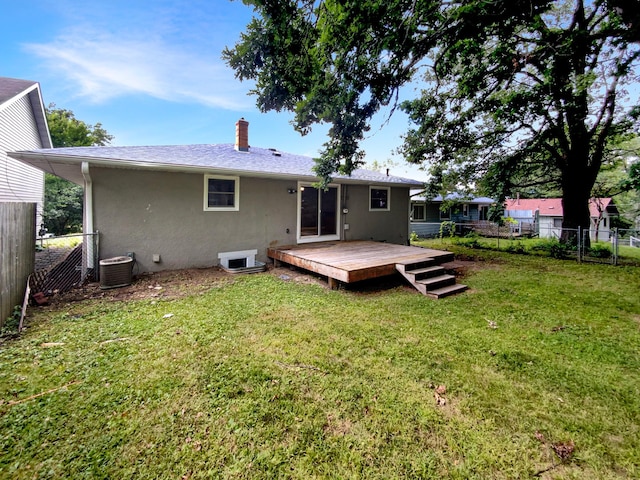 rear view of property with a lawn, a deck, and central air condition unit