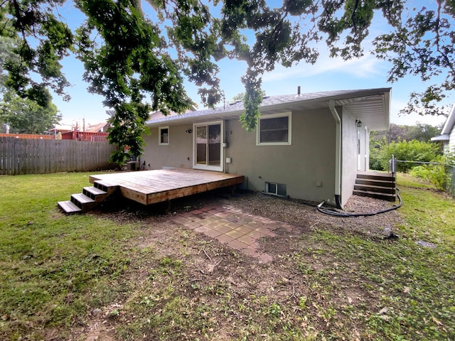 rear view of property featuring a deck and a lawn