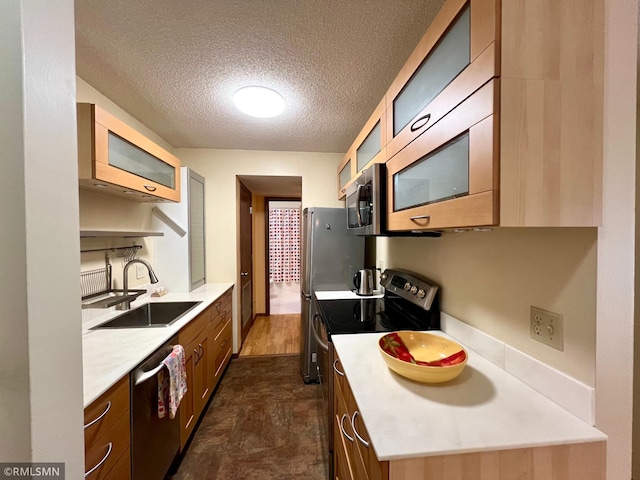 kitchen featuring appliances with stainless steel finishes, a textured ceiling, and sink