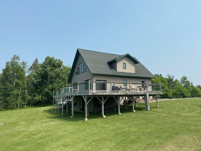 rear view of house featuring a wooden deck and a lawn