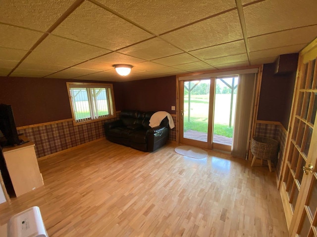 unfurnished room featuring wood-type flooring and a drop ceiling