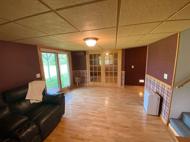 living room featuring french doors and a drop ceiling