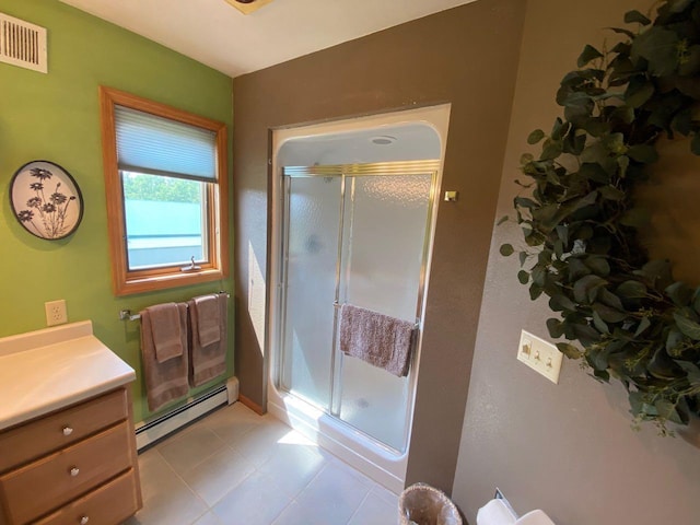 bathroom featuring baseboard heating, tile patterned floors, walk in shower, and vanity