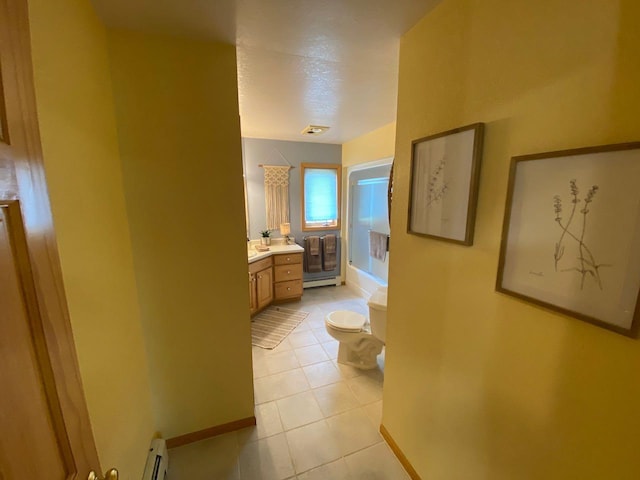 hallway featuring baseboard heating and light tile patterned floors