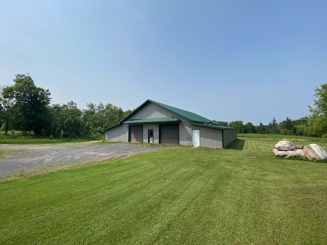 view of front of home featuring a garage, a front yard, and an outdoor structure