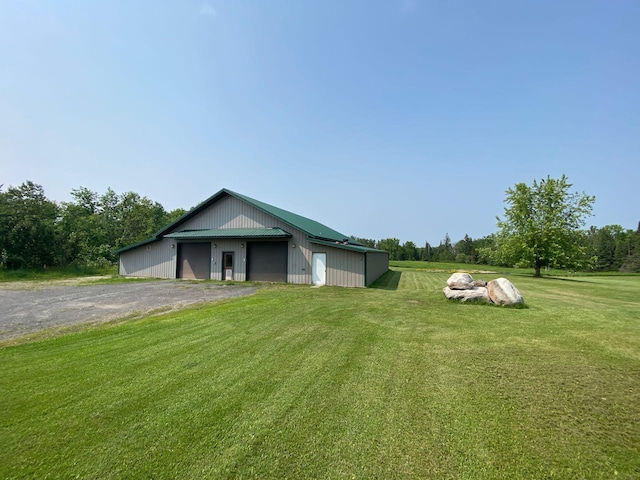 view of front facade with a front yard, an outbuilding, and a garage