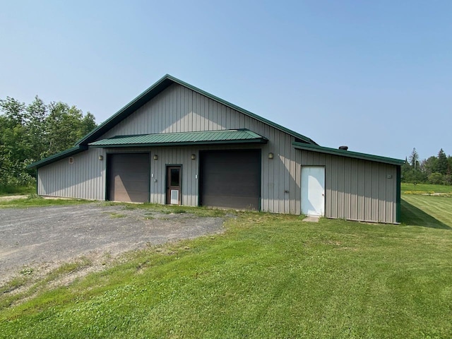 view of outdoor structure with a garage and a lawn