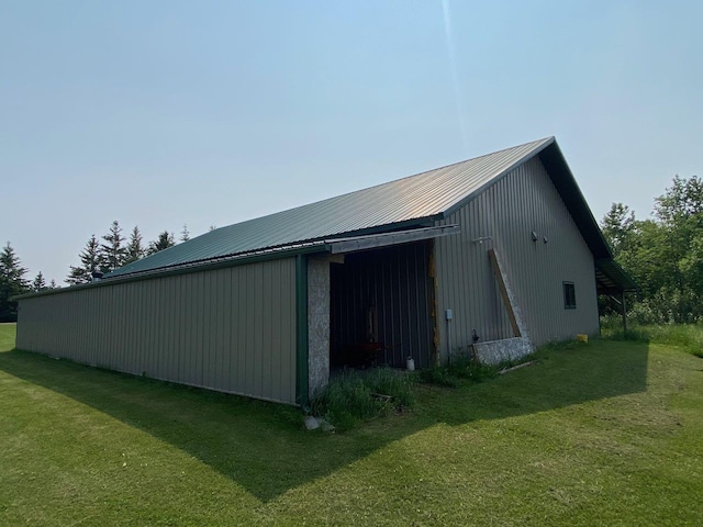 view of property exterior with an outdoor structure and a lawn