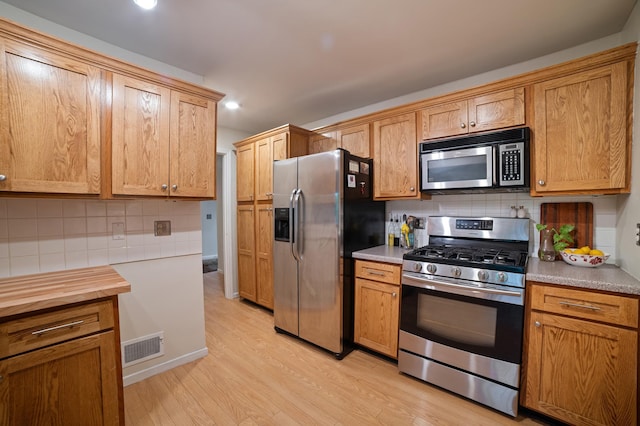 17661 Southridge Ct, Minnetonka, MN 55345 - kitchen with stainless steel appliances, decorative backsplash, light wood-type flooring, and recessed lighting