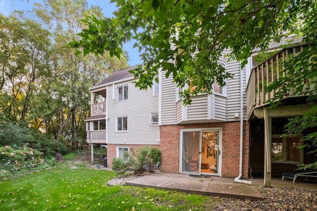 17661 Southridge Ct, Minnetonka, MN 55345 - back of house featuring a balcony, a yard, and brick siding