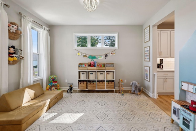 recreation room featuring baseboards and light wood-style flooring