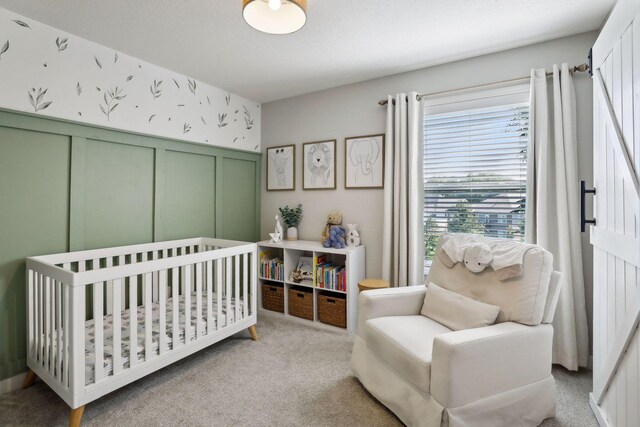 carpeted bedroom with a nursery area