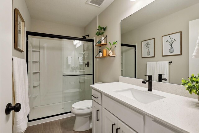 bathroom featuring an enclosed shower, vanity, and toilet