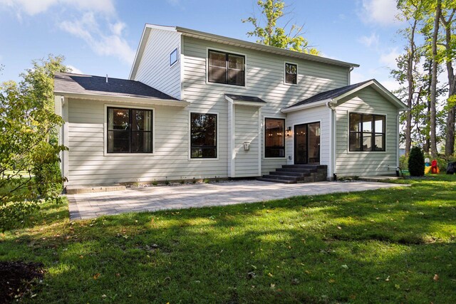 rear view of property featuring a yard and a patio