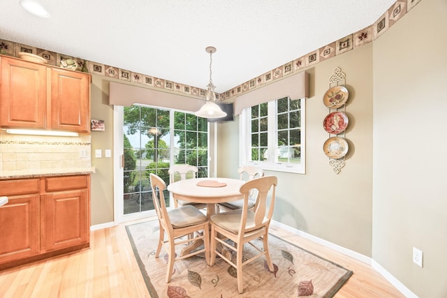 dining area featuring light wood-type flooring and baseboards