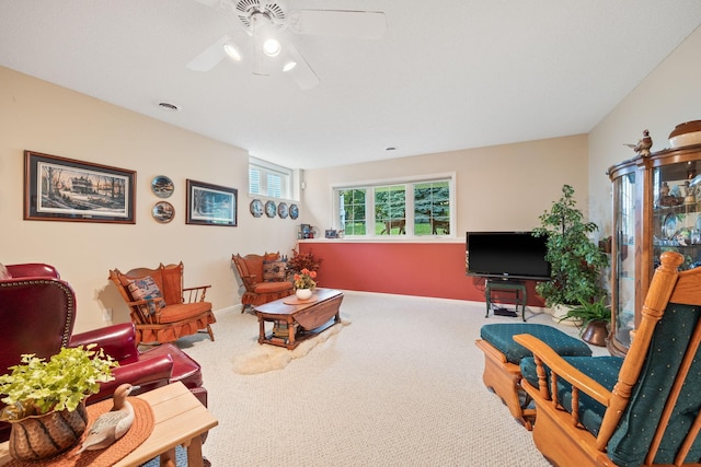 living room featuring a ceiling fan, carpet flooring, visible vents, and baseboards