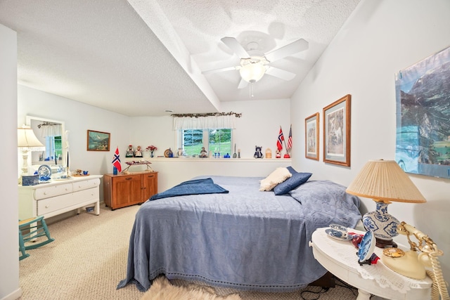 bedroom featuring light carpet, a ceiling fan, and a textured ceiling