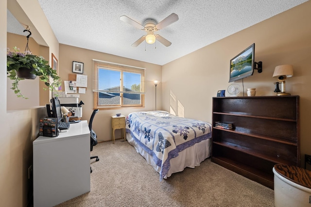 bedroom with a textured ceiling, a ceiling fan, and light colored carpet